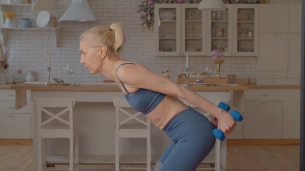 在室内练习哑铃三头肌反冲运动 调理手臂 增加体格力量的运动中 精力充沛 健康的年长女士穿着运动服 — 图库视频影像