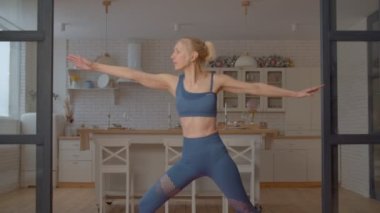 Aktif spor fitness çekici son sınıf kadın yoga savaşçısı iki egzersiz, esneme kalçalar, kasıklar ve omuzlar. iç odada spor yaparken..