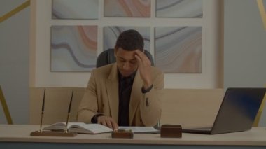 Düşünceli yakışıklı siyah erkek yönetici iş kararları üzerinde kafa yoruyor, modern ofiste çalışırken yeni sözleşme ve finansal yatırımın başarısı hakkında şüpheleri var..