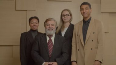 Portrait of successful positive diverse multiethnic business team standing with arms crossed , looking with cheerful radiant smiles, expressing friendliness, unity and confidence while posing at