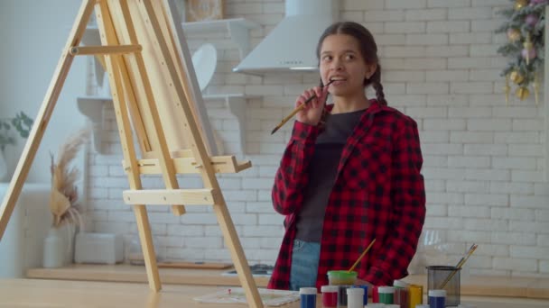 Thoughtful Creative Lovely Hispanic Teenage Girl Painter Paintbrush Mouth Standing — 비디오