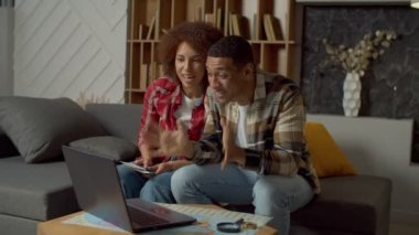 Heyecanlı yakışıklı Afro-Amerikalı adam ve neşeli siyah kadın internette bilgisayar kullanarak video görüşmesi yapıyorlar. Pasaportları seyahat biletleriyle birlikte gösteriyorlar ve arkadaşlarıyla yaz gezilerini paylaşıyorlar..