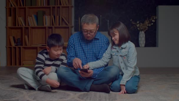 Caring Lovely Elementary Age Grandchildren Helping Handsome Grandfather Eyeglasses Use — Vídeo de Stock