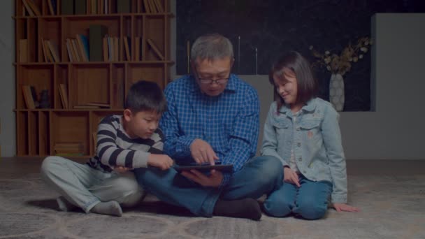 Smart Positive Adorable Preadolescent Asian Sibling Teaching Attractive Grandfather Eyeglasses — Video Stock