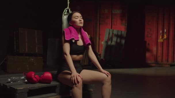 亚洲女子跆拳道手坐在货盘上 深呼吸 精疲力竭 精疲力竭 在运动训练结束后在牢骚体育馆休息的形象 — 图库视频影像