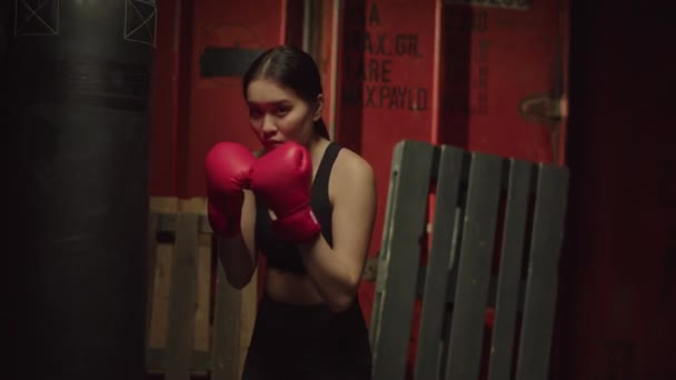 身穿拳击手套的亚洲女子运动员 立正立正 准备参加拳击训练 表现出对体操的决心和信心 — 图库视频影像