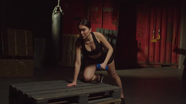 决心积极运动的漂亮亚洲女人在黑暗的车库健身房进行举重训练 练习单臂哑铃 加强肩膀 上臂和核心肌肉 — 图库视频影像