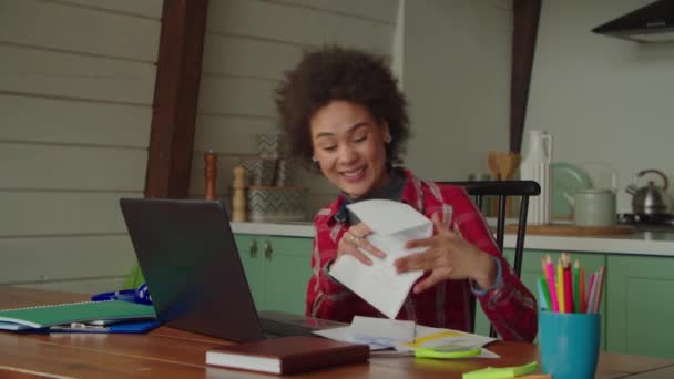 兴奋而又有魅力的黑人女性与朋友聊着大学入学的事 一边自豪地展示大学录取通知书 一边在家里用笔记本电脑在电视上交谈 — 图库视频影像