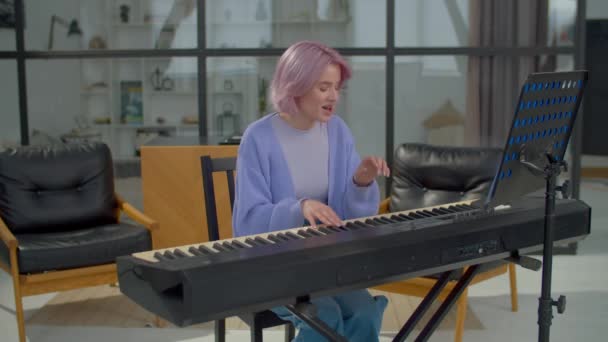 Pozitif Yetenekli Pembe Saçlı Bayan Müzisyen Elektronik Piyano Klavyesi Çalıyor — Stok video