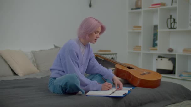Geïnspireerd Getalenteerd Charmant Roze Harige Vrouwelijke Componist Die Teksten Notitieblok — Stockvideo