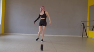 Zarif karizmatik, ince, çekici, pembe saçlı, doğaçlama dans eden, dans pistinde zarif bir şekilde dans eden stüdyo seyircilerine canlı yayın video içeriği sunan,.