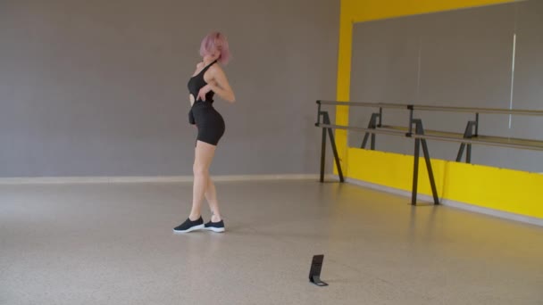 优雅纤细迷人的粉色头发女舞蹈演员穿着活动服装表演自由式嘻哈舞 一边在舞蹈工作室排练一边在手机上为社交媒体录制Vlog — 图库视频影像