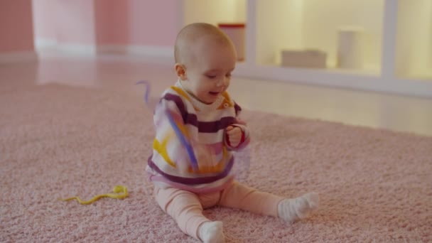 Πορτρέτο Χαρούμενα Θετικά Χαριτωμένο Κοριτσάκι Βρέφος Κάθεται Στο Πάτωμα Διασκεδάζοντας — Αρχείο Βίντεο