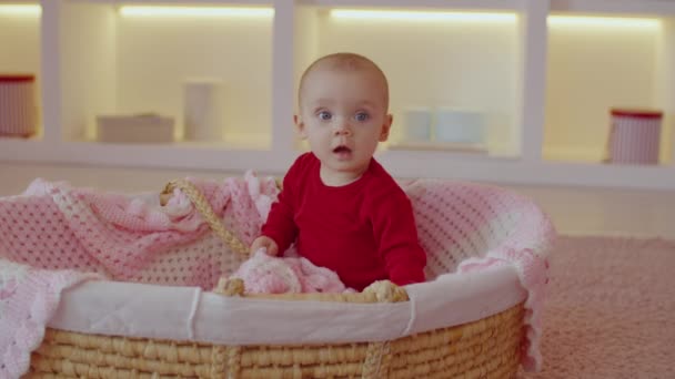 Positivo Curioso Adorable Bebé Ojos Azules Sentado Cuna Cesta Mirando — Vídeo de stock