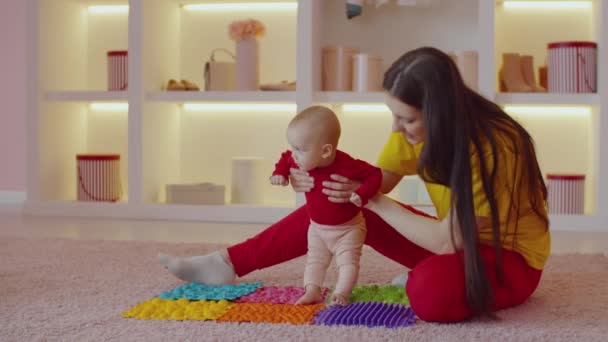 Симпатична Дівчинка Немовля Босоніжкою Допомогою Турботливої Матері Ступає Ортопедичний Масажний — стокове відео