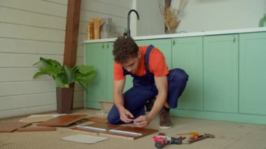 Konsantre olmuş, koruyucu iş kıyafetleri içinde, DIY mobilyaları monte eden, kendi kendine kapanan çekmeceler takan, evde tornavidayla vidaları sıkmaya çalışan Afro-Amerikan genç adam..