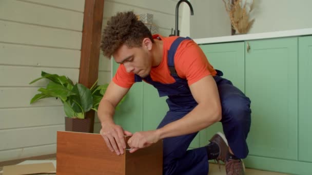 Konzentrierter Gutaussehender Schwarzer Heimwerker Schutzkleidung Montiert Diy Nachttisch Schraubt Selbstschneidende — Stockvideo