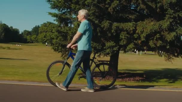 Vista Lateral Homem Sênior Bonito Positivo Roupas Casuais Segurando Bicicleta — Vídeo de Stock