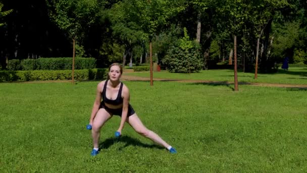 決定されたアクティブライフスタイル スポーツウェアの素敵なフィット感の女性 練習クロストレーニング ダンベルサイド肺運動 太もももを強化 ヒップ アウトドアトレーニング中に脚筋 — ストック動画