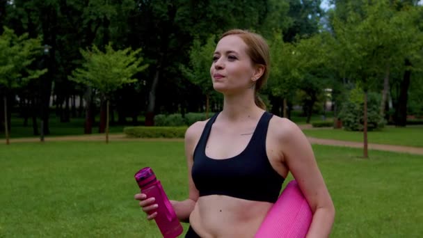 Активна Атлетична Жінка Тримає Тренувальний Килимок Ходить Парку Зелений Газон — стокове відео