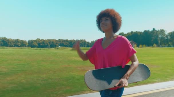 Wanita Afrika Amerika Yang Periang Dan Menarik Memegang Skateboard Berjalan — Stok Video