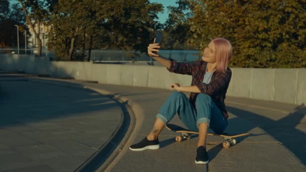 Carefree Trendy Cool Pink Haired Female Skateboarder Sitting Skateboard Posing — Stock Video
