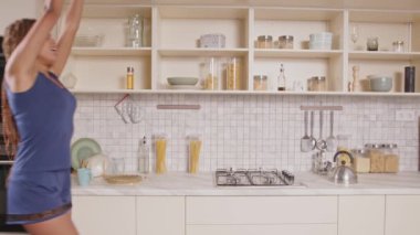 Gecelikli rahat, çekici, siyah kadın uyandıktan sonra yepyeni bir başlangıç yapıyor. Kollarını esnetiyor, ocağa su ısıtıcısı koyuyor. Mutfakta keyfine bakarken kahve yapıyor..