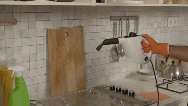 国内キッチンでグリースからキッチンストーブを洗いながら 保護グローブで黒人男性手のクローズアップ — ストック動画