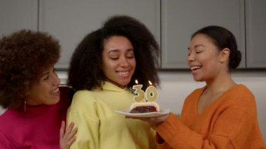Mutlu, güzel, siyah bir kadın doğum gününde tebrik alıyor, doğum günü pastasında dilek diliyor ve mum üflüyor. Bu sırada neşeli bayan arkadaşlarıyla birlikte evde kutlama yapıyorlar..