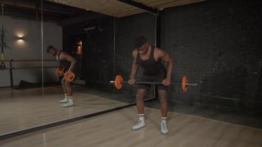 Aktif motivasyonlu sportif kas yapısı Afrikalı adam halter antrenmanı yapıyor, halter sıra egzersizi yapıyor, iç mekanda vücut ve sırt kaslarını güçlendiriyor..