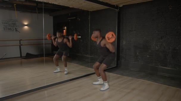 決定された筋肉のビルドの側面のビルドのアフリカ人男性は 体重トレーニング バーベルスクワット運動 脚とコア筋肉の強化 ジムでの姿勢とモビリティの向上 — ストック動画