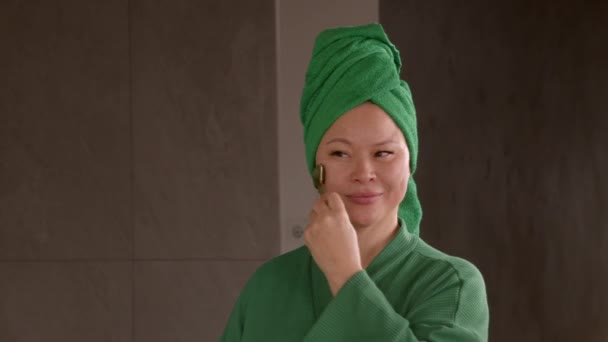 Позитивный Привлекательный Зрелая Азиатская Женщина Халате Делает Массаж Лица Помощью — стоковое видео