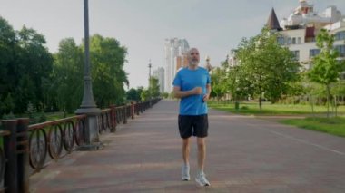 Motivasyonlu spor fitness yakışıklı orta yaşlı erkek koşu antrenmanı, gün doğumunda şehir caddesinde spor eğitimi sırasında koşma.