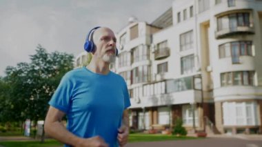 Aktif motive olmuş, olgun bir adamın portresi. Kablosuz kulaklıkla müzik dinliyor, sabah sokaklarda koşarken kardiyo çalışması yapıyor..