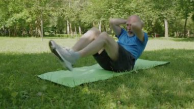 Motive olmuş, orta yaşlı sporcu spor yapıyor spor yapıyor spor yapıyor spor yapıyor spor yaparken spor yapıyor spor yaparken spor yapıyor spor yaparken vücut kaslarını ve kaslarını esnetiyor vücut gücünü, dengeyi ve esnekliğini geliştiriyor..