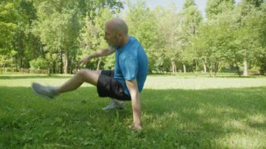 Aktif motivasyonlu spor fitness orta yaşlı adam vücut ağırlık antrenmanı yapıyor ve egzersiz yapıyor, kamu parkında vücut kaslarını güçlendiriyor.