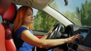 Çekici kızıl saçlı olgun kadın sürücü şık günlük kıyafetler içinde seyahat yerini seyahat bilgisayarında GPS navigatör haritasıyla seçiyor, iş seyahatinde araba sürerken en iyi rotayı arıyor..