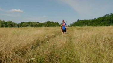 Neşeli, tapılası ergen kız babasının omzunda oturuyor, kollarını açıp uçtuğunu hayal ederken süper kahraman kostümlü kaygısız bir aile sahada eğleniyor ve yürüyor..