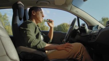 Rahat, yakışıklı, Afro-Amerikan erkek sürücü arabada oturuyor, trafik sıkışıklığında trafik sıkışıklığında buharlaşıp duruyor..
