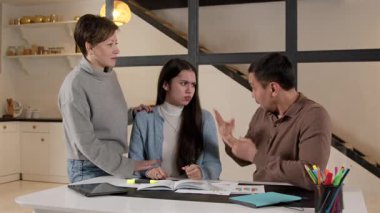 Sevecen, üzgün, işitme engelli bir kızı destekleyen çekici ebeveynler eğitim materyallerini anlamakta zorluk çeken evde sevgi ve özen göstermekte zorlanıyorlar..