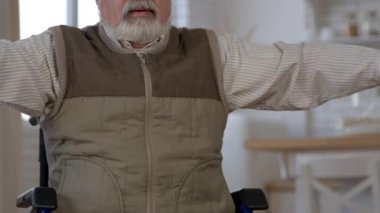 Tekerlekli sandalyedeki motive olmuş son sınıf öğrencisinin, halterin önünde yükseltme egzersizi yapması, uzun vadeli bakım tesislerinde kol kaslarının güçlendirilmesi..