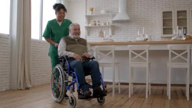 Üniformalı, çekici, Afro-Amerikan kadın bakıcı. Mutlu, gri saçlı, yaşla ilgili sağlık sorunları olan bir adamla iletişim kuruyor. Huzurevinde tekerlekli sandalye sürüyor..