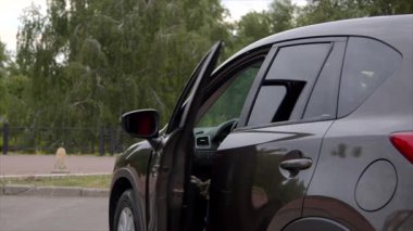 Kendine güveni olan, tablet bilgisayarı ve günlük kıyafetleriyle çekici siyah bir kadın park halindeki arabayı terk ediyor, iş toplantısına gidiyor ve şehirde araba sürüyor..