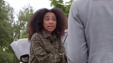 Şehir caddesinde araba kazasından sonra kadın sürücüyle duygusal olarak tartışan sinirli Afrikalı Amerikalı bir kadının portresi..