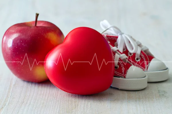 Canvas shoes, apple and red heart with cardiogram line, diet and sport for healthy heart concept
