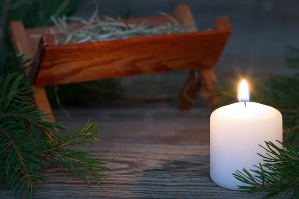 在背景 祈祷和等待耶稣的到来方面焚烧蜡烛和圣诞马槽 — 图库照片