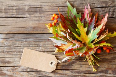 Tahtada boş etiketli sonbahar yaprakları.