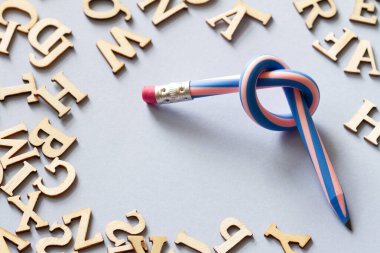 Pencil with knot and scattered letters, dyslexia concept clipart
