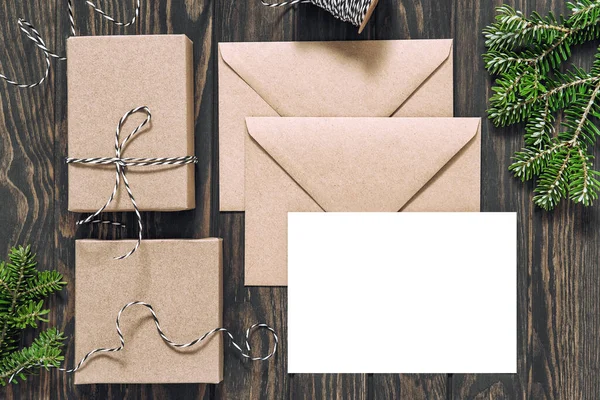 圣诞节模拟了 简朴木制背景的圣诞信纸和礼品盒 — 图库照片