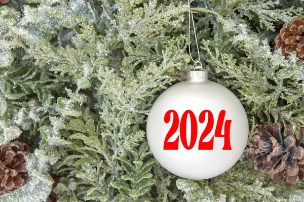Bauble Bianco Con 2024 Sopra Albero Natale Rami Decorazione Sfondo Foto Stock